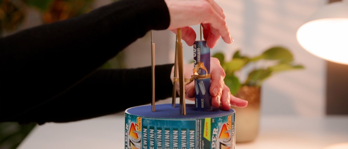 WestLotto-Rubbellos-Röllchen wird auf DIY-Torte fixiert