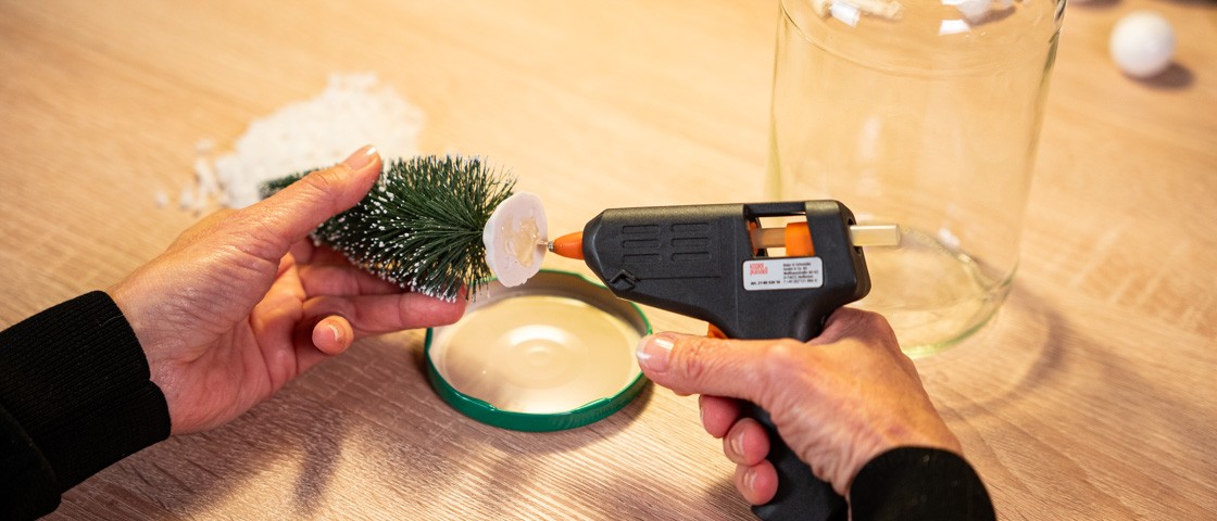 Kleber wird mit Hilfe einer Heißklebepistole an ein Deko-Bäumchen aufgebracht | WestLotto Bastelidee