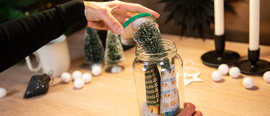 Deckel mit aufgeklebtem Deko-Bäumchen wird auf ein Gurkenglas geschraubt | WestLotto Bastelidee